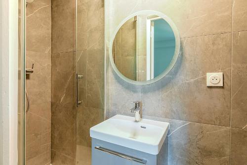 une salle de bain avec un lavabo et un miroir dans l'établissement Studio lumineux à deux pas des commerces- Asnières, à Asnières-sur-Seine