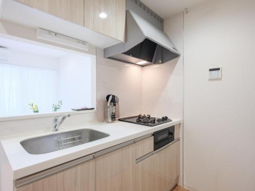 a kitchen with a sink and a window at 期間限定セール中 - The River Up Palace -ザリバーアップパレス- 三井ｱｳﾄﾚｯﾄﾊﾟｰｸ木更津徒歩9分 ﾌﾟﾛｼﾞｪｸﾀｰや駐車場付の1LDK in Kisarazu