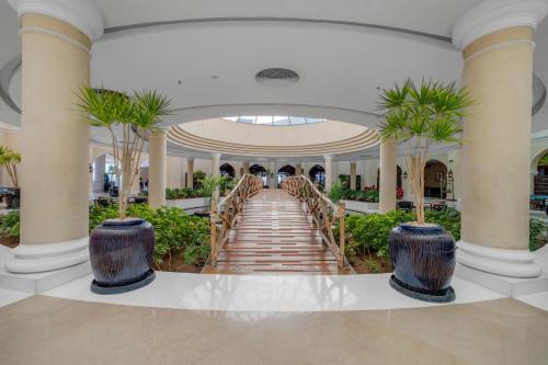 a hallway with palm trees and stairs in a mall at Savoy Sharm El Sheikh in Sharm El Sheikh