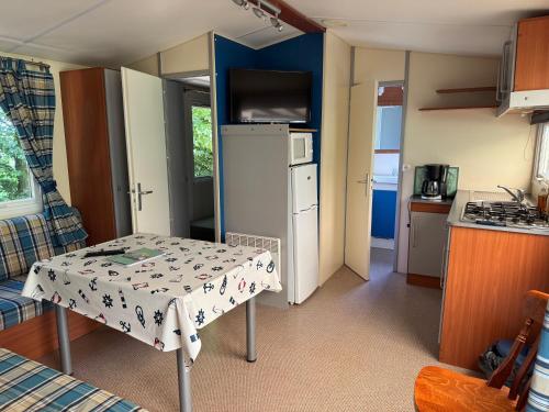 une petite cuisine avec une table et un réfrigérateur dans l'établissement camping de la mottelette, à Forest-Montiers