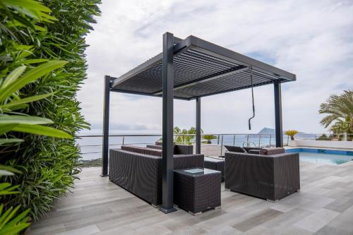 a pergola over a patio with a pool at AVANOA - Sierra Altea in Alicante