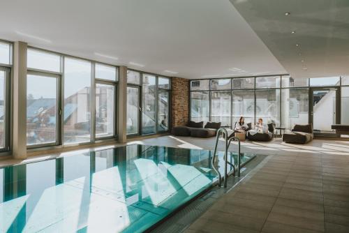 a swimming pool in a building with glass windows at H5 Grauer Bär Studios & More in Innsbruck