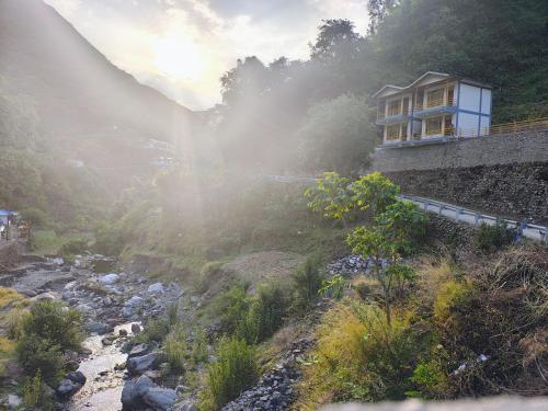 a house on a hill next to a river at Neerangana Retreat in Chakrāta