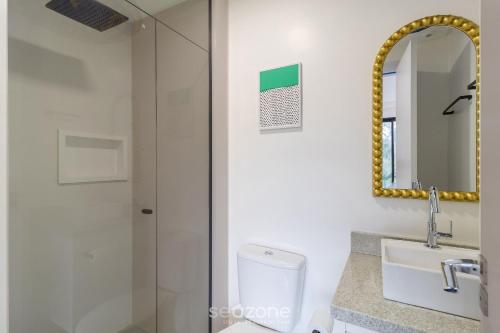 a bathroom with a toilet and a sink and a mirror at RUP - Studios Equipados em Prédio com Piscina in Blumenau