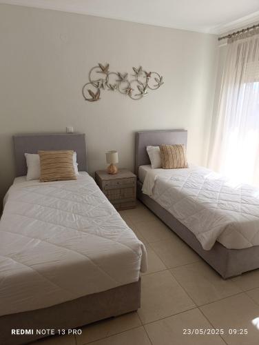 two beds sitting next to each other in a bedroom at Pearl Apartments in Ofrínion