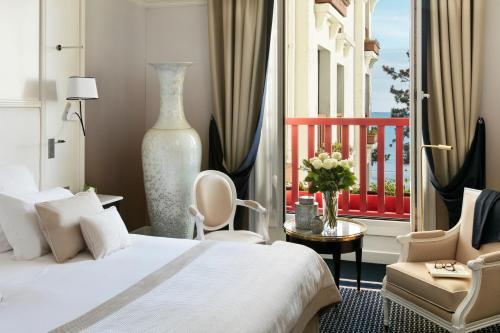 una camera d'albergo con un letto e un balcone di Hôtel Barrière L'Hermitage a La Baule