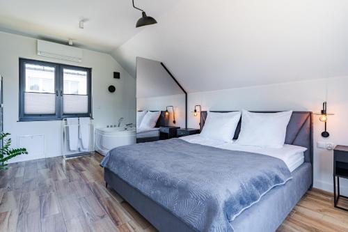 una camera da letto con un letto grande e una vasca da bagno di Cztery Klimaty a Stegna