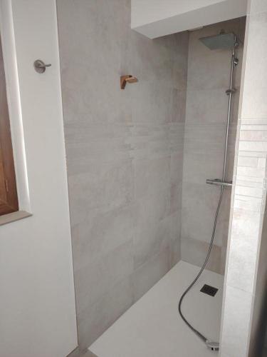 une douche avec une porte vitrée dans une salle de bain dans l'établissement Le perchoir, à Les Mayons