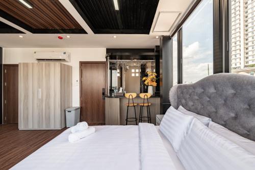a bedroom with a large white bed and a large window at A Boi Apartment at District 3 in Ho Chi Minh City