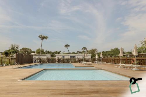 einen Pool mit einer Holzterrasse und einem Pool in der Unterkunft HOTIDAY Room Collection - Milano Marittima in Milano Marittima