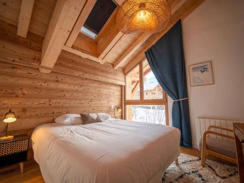 ein Schlafzimmer mit einem großen Bett in einem Holzzimmer in der Unterkunft Chalet familial à Valmorel pour 24 personnes avec sauna et grandes terrasses - FR-1-291-1009 in Les Avanchers