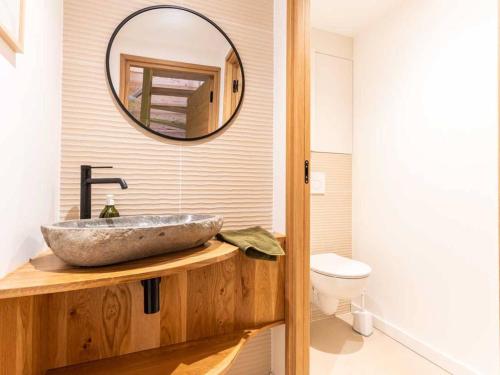 ein Badezimmer mit einem Steinwaschbecken und einem Spiegel in der Unterkunft Chalet familial à Valmorel pour 24 personnes avec sauna et grandes terrasses - FR-1-291-1009 in Les Avanchers