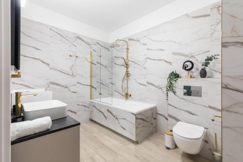 a bathroom with a sink and a toilet and a tub at SuperApart Przy Forcie 12 in Warsaw