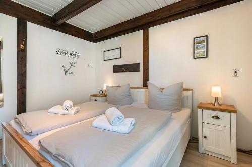 a bedroom with two beds with towels on them at Fewo To Huus Pellworm in Pellworm