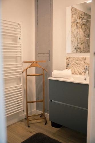 La salle de bains est pourvue d'un lavabo et d'un tabouret en bois. dans l'établissement Le Château de La Seigne, à Villemoustaussou