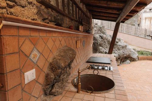a kitchen with a sink in a brick wall at CONVIVIUM - Suites Apartments in Randazzo