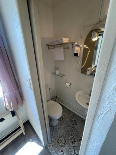 a bathroom with a toilet and a sink and a mirror at Hotel Clair Logis in Argelès-sur-Mer