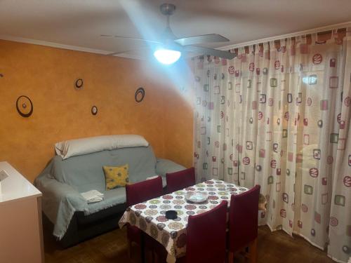 a room with a table and a bed and a ceiling fan at Apartamento en el faro de Cullera in Cullera