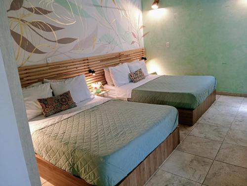 two beds in a hotel room with two bedsvisor at Tauro Black Suites Cerca al estadio Atanasio Girardot in Medellín