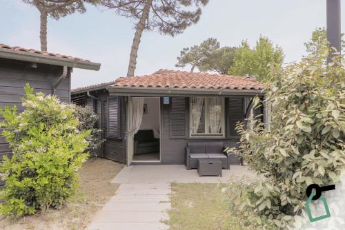 a house with a porch with a couch and trees at Hotiday Milano Marittima Pineta in Milano Marittima