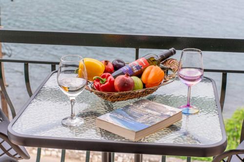 a table with a basket of fruit and wine glasses at Casa Mare2 in Ayia Evfimia