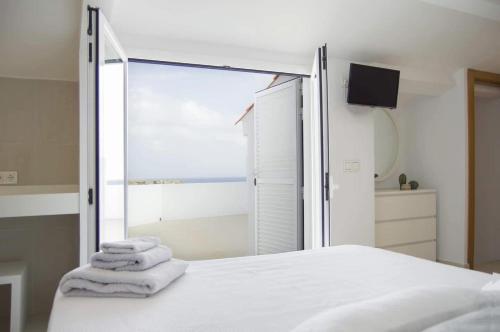 a bedroom with a bed with towels on it at BINIPARADISE Villas in Binibeca