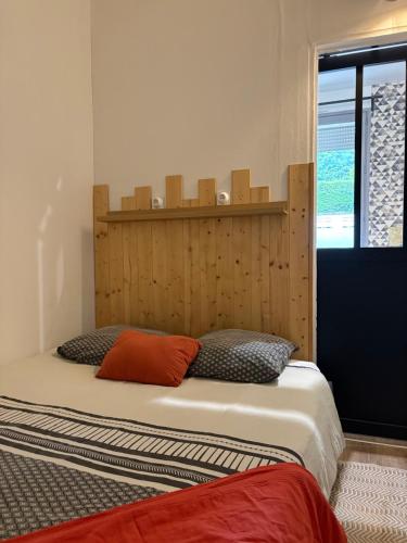 une chambre avec un lit avec une tête de lit en bois dans l'établissement L'Atelier 9 - Hypercentre Rouen, à Rouen