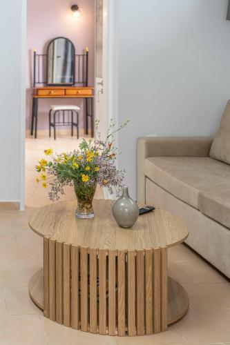a wooden coffee table with a vase of flowers on it at Casa Mare2 in Ayia Evfimia