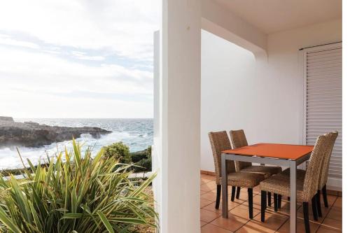a dining room with a table and chairs and the ocean at BINIPARADISE Villas in Binibeca