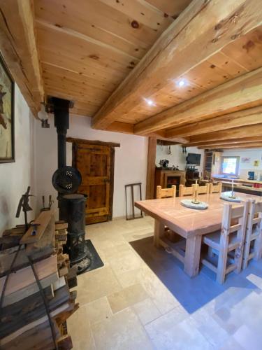 - une salle à manger avec une table en bois et un poêle à bois dans l'établissement Chalet Alpage aux portes du Queyras, à Guillestre