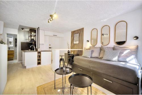 Cet appartement comprend une chambre avec un lit et deux chaises ainsi qu'une cuisine. dans l'établissement Modern studio in the historic center of Grasse, à Grasse