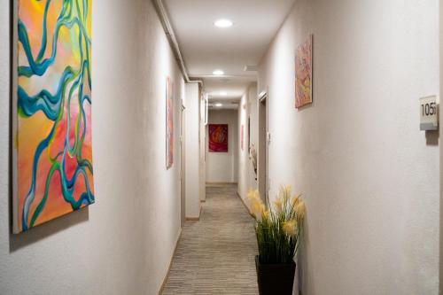 a hallway with colorful paintings on the walls at Hotel Victoria in Cuneo