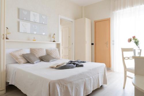 a bedroom with a bed with white sheets and pillows at Hotel Mondial in Bellaria-Igea Marina