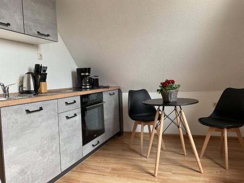 a kitchen with a table and two chairs and a stove at Landhaus am Bärenstein Pano-Blick 2 in Bärenstein