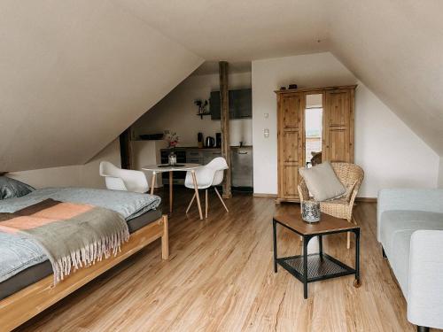 a bedroom with a bed and a table and chairs at Landhaus Bärenstein - Pano-Blick 1 in Bärenstein