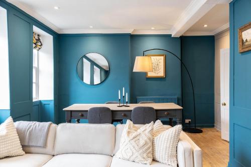 a living room with blue walls and a white couch at Woodstock Nest in Woodstock