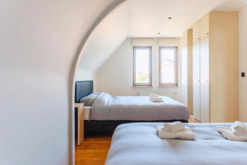 ein Zimmer mit zwei Betten mit Handtüchern darauf in der Unterkunft Villa Croisette in Nieuwpoort
