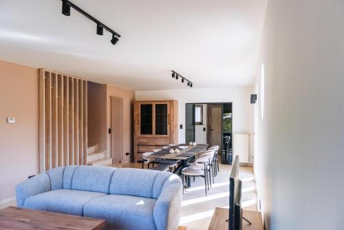 ein Wohnzimmer mit einem blauen Sofa und einem Tisch in der Unterkunft Villa Croisette in Nieuwpoort