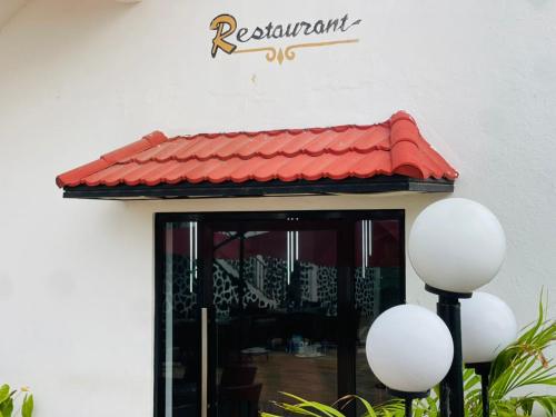 a door to a restaurant with a red roof at Hotel Barmoi in Freetown