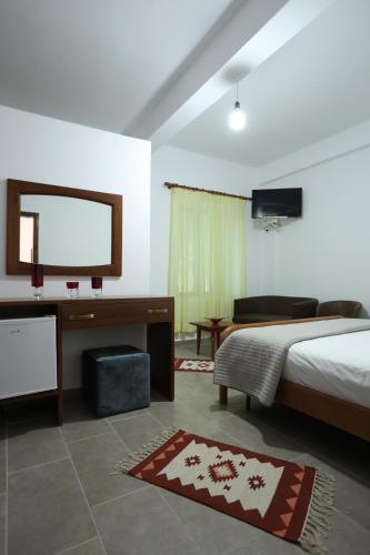 a bedroom with a bed and a flat screen tv at Te Rrapi Rooms in Qeparoi i Sipërm