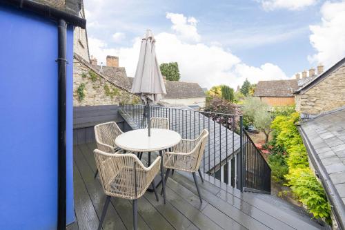 a table and chairs on a balcony with an umbrella at Woodstock Nest in Woodstock