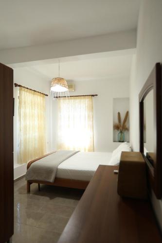 a bedroom with a large bed and a window at Te Rrapi Rooms in Qeparoi i Sipërm