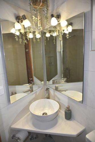 a bathroom with a sink and a large mirror at Evanthia Toroz Rooms & Studios in Mithymna