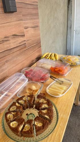 a table with a pie and other food on it at Residência Lençóis Pousada in Barreirinhas