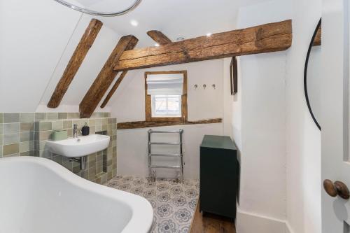 a bathroom with a white tub and a sink at Woodstock Nest in Woodstock