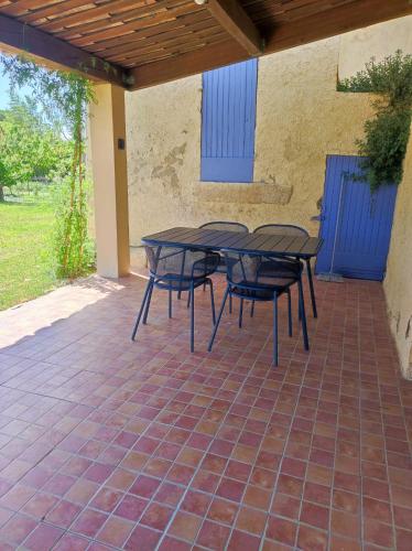 une table et des chaises assises sur une terrasse dans l'établissement Les petits volets bleus, à Bouchet