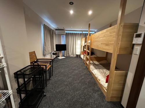 a room with two bunk beds and a television at 新三条Home in Asahikawa
