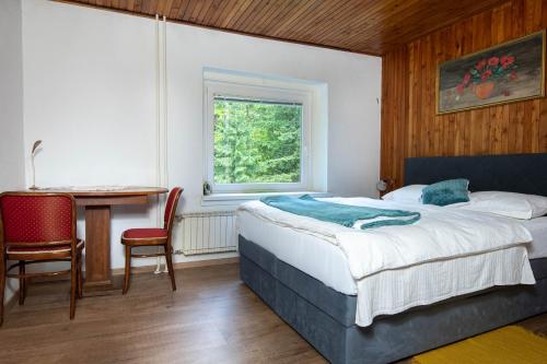 a bedroom with a bed and a table and a window at House Angelca in Hočko Pohorje