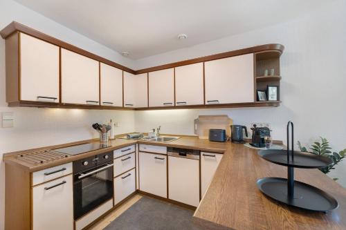 a kitchen with white cabinets and a wooden counter top at Ferienhaus Rotkreuz in Haslach im Kinzigtal