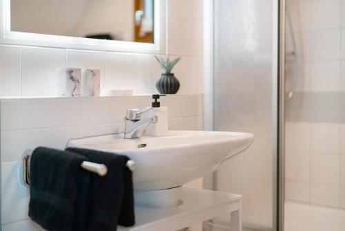 a white bathroom with a sink and a mirror at Ferienhaus Rotkreuz in Haslach im Kinzigtal